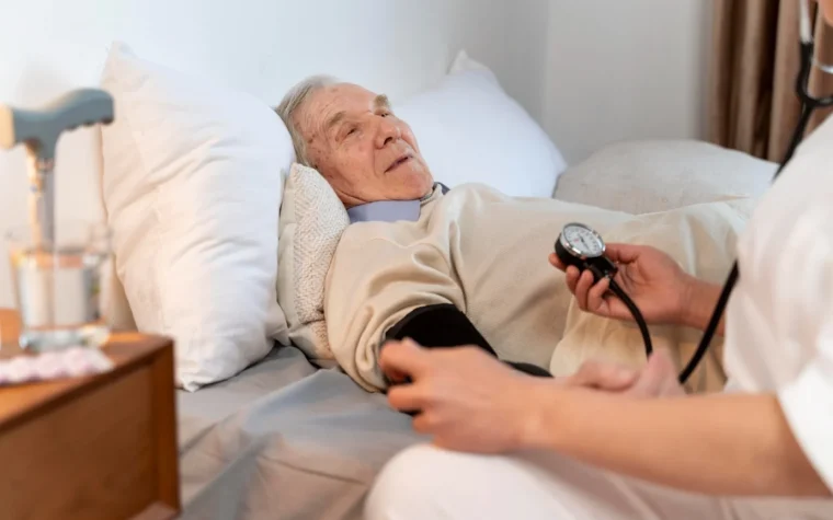 Professionnel de santé mesurant la tension d’un senior à domicile