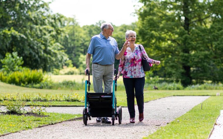 Senior marchant tranquillement dans un parc sur un chemin plat