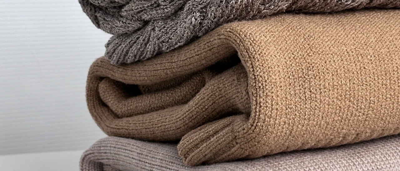 Plaids en maille empilés dans un intérieur clair