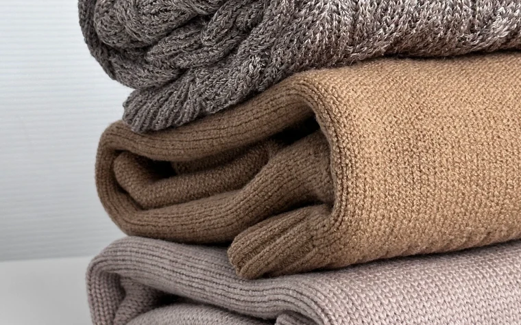 Plaids en maille empilés dans un intérieur clair